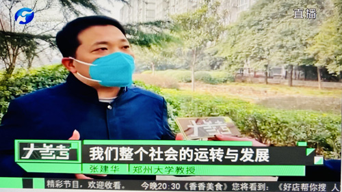 郑州大学张建华教授在盛和苑南门接受河南电视台记者采访，点评河南拨款80亿元助力抗疫